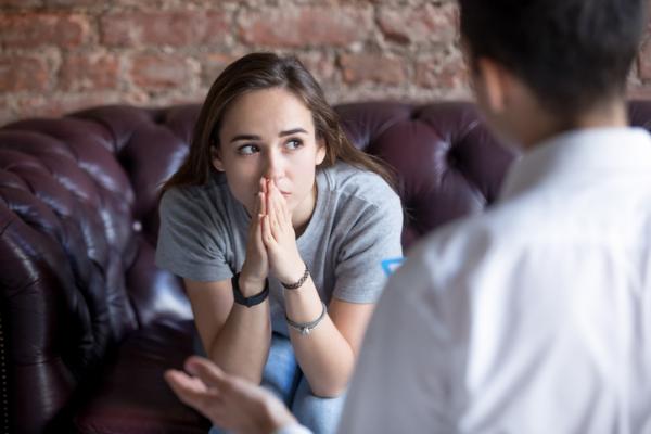 Girl sitting on leather sofa receives bad news