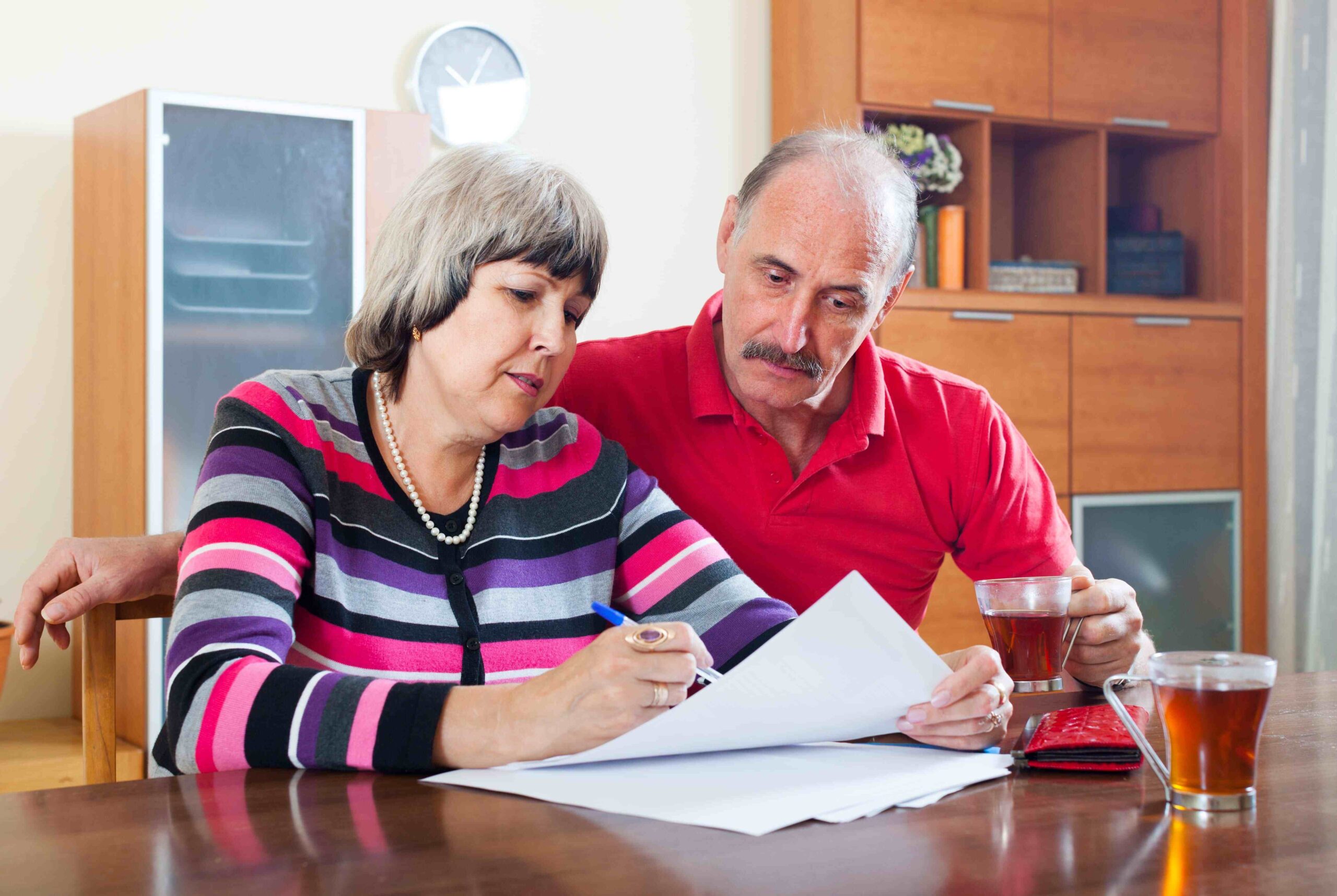 serious mature couple fills in questionnaire together at home interior