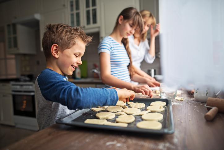 Children baking cookies with parent