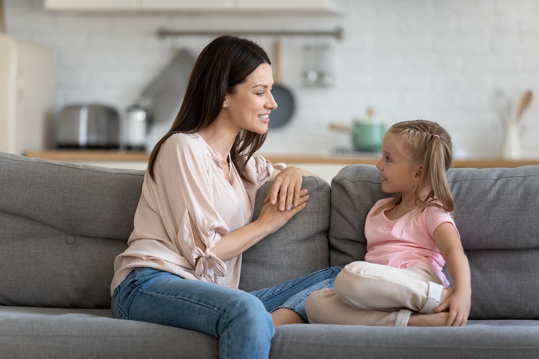 women talking to a young girl on the sofa