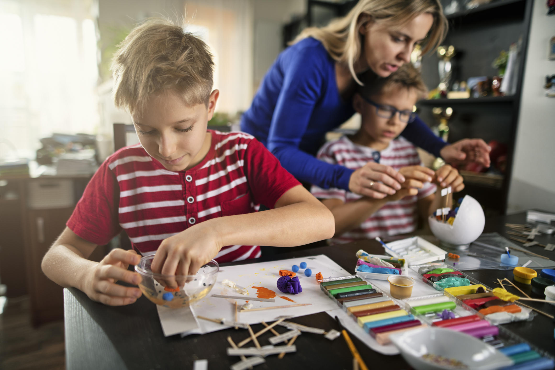 foster mum helping 2 foster children play crafts
