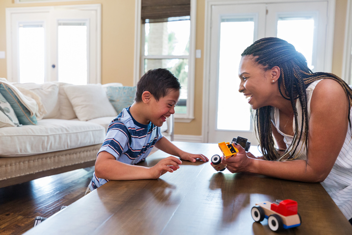 Young woman with boy and toy tractors