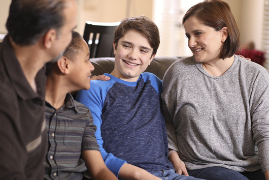 Foster carers smiling with their foster children