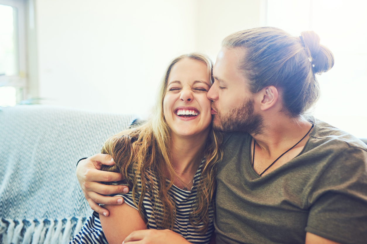 man kissing woman on cheek