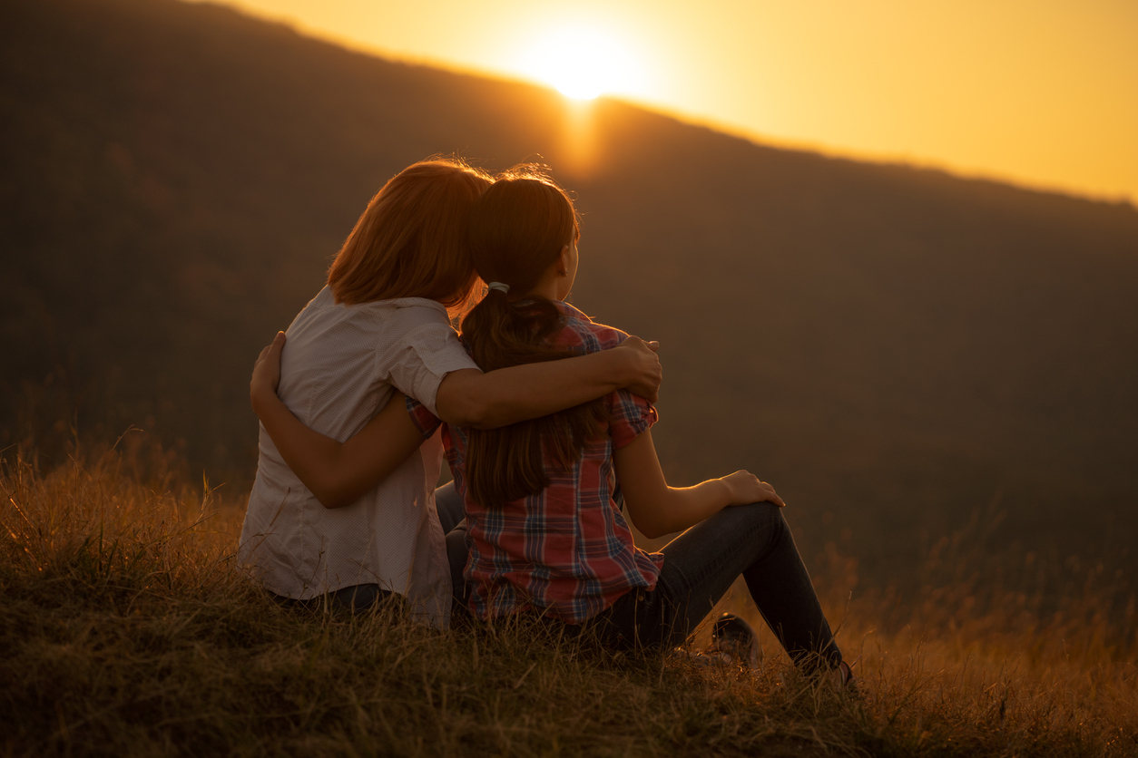 Foster carer with foster child watching sunset