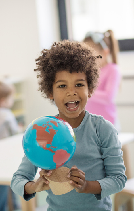 young boy holding a globe