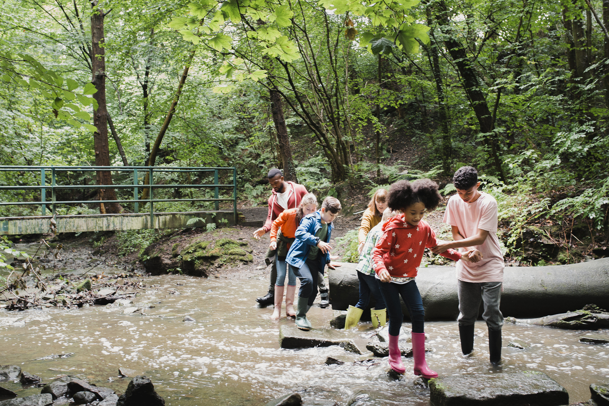 Group of foster children in a forest next to a riverfoster children in a forest next to a river