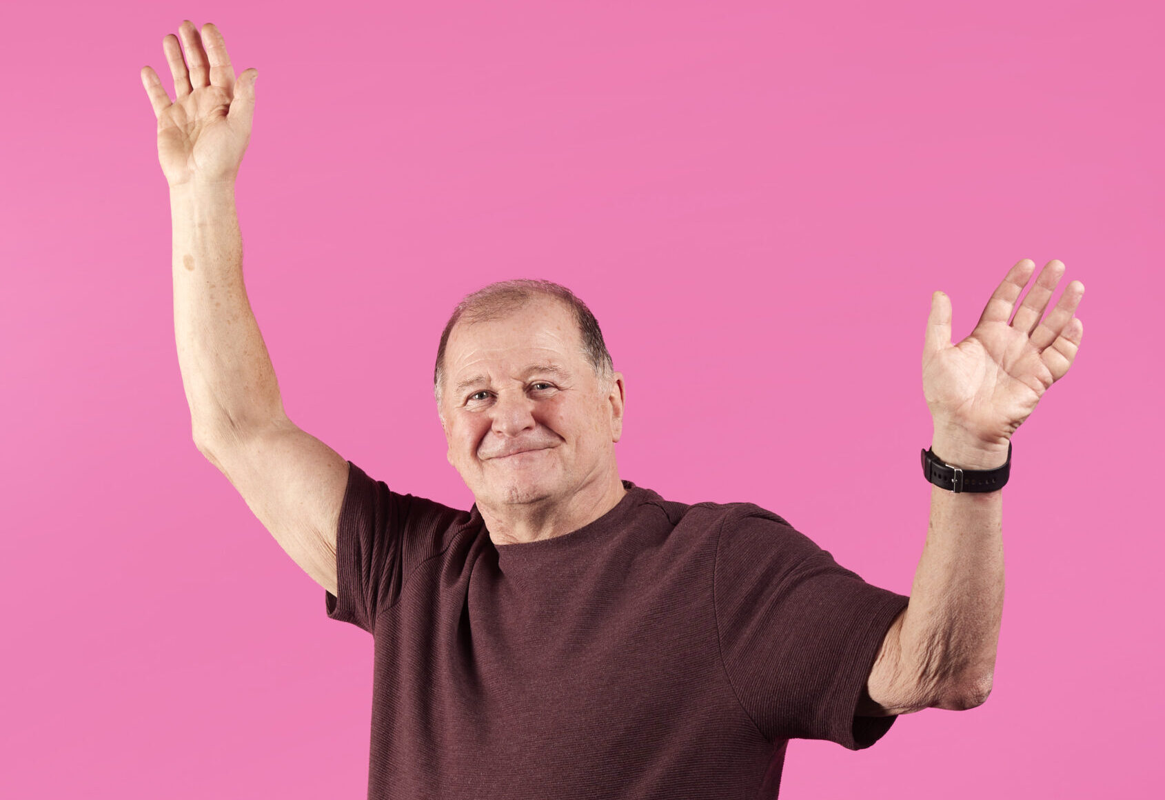 Foster carer Stephen with his arms in the air smiling